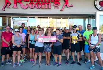 Kelowna Running Room staff holding a large check