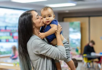 Brandi holding and kissing a baby