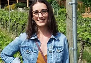 Kristen smiling in the vineyard