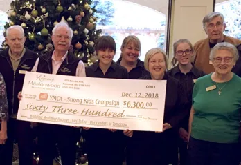 Missionwood Retirement Resort staff and seniors holdign a large check