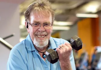 Bob smiling while lifting a dumbbell