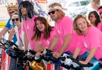 people in pink shirts riding bikes