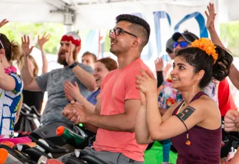people raising their hands on bikes