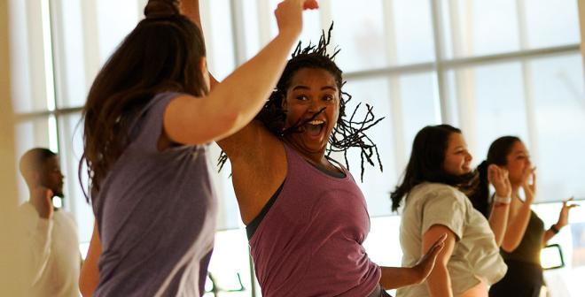 Women enthusiastically participating in a fitness class and enjoying each other's company