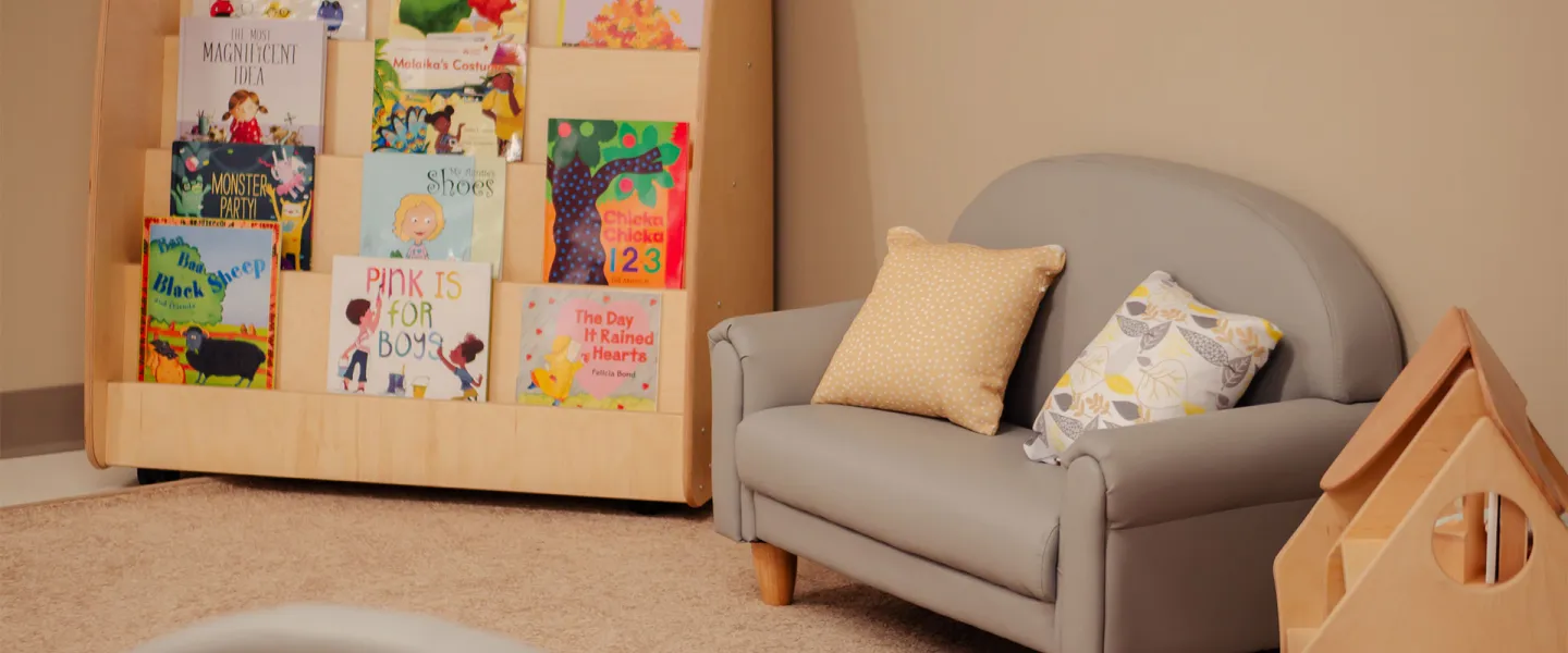 reading corner with books, dollhouse and child-sized couch