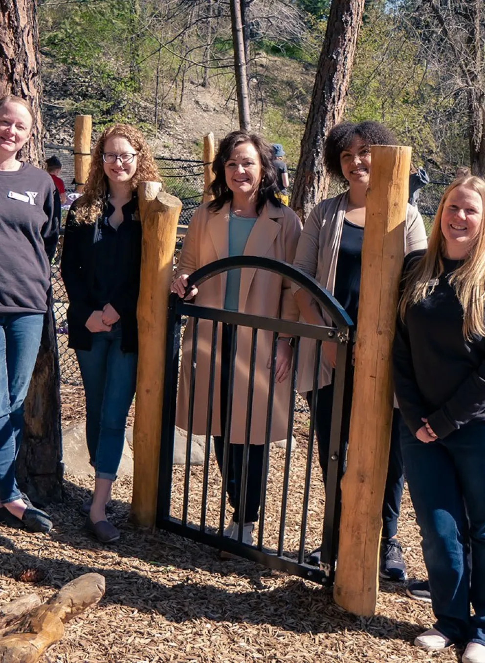 child care team standing in natural playground at Dilworth Mountain YMCA Child Care centre