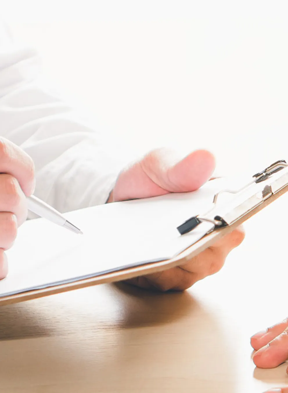 clipboard being written on by doctor