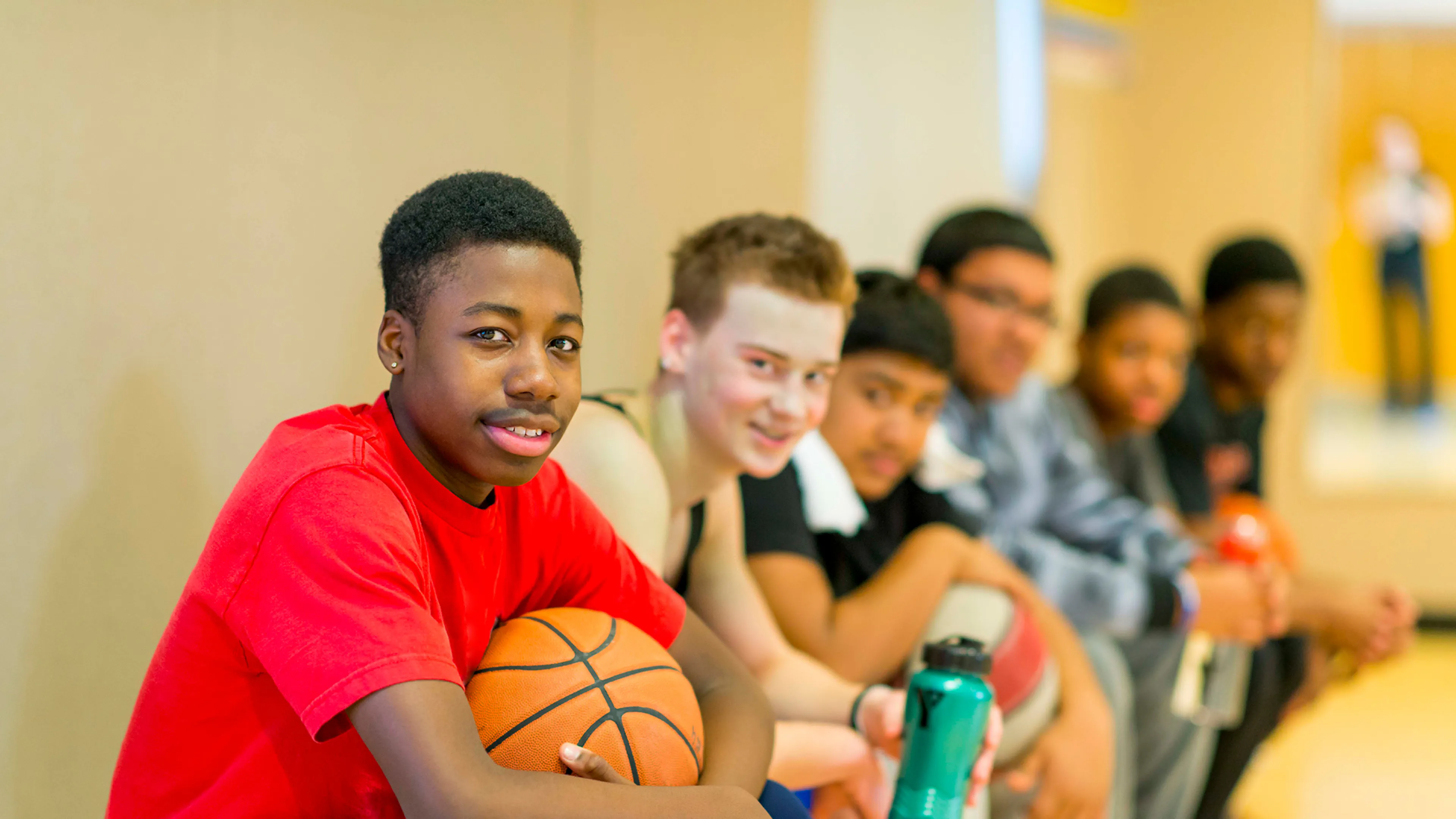 Young guys sitting on the basketball bench