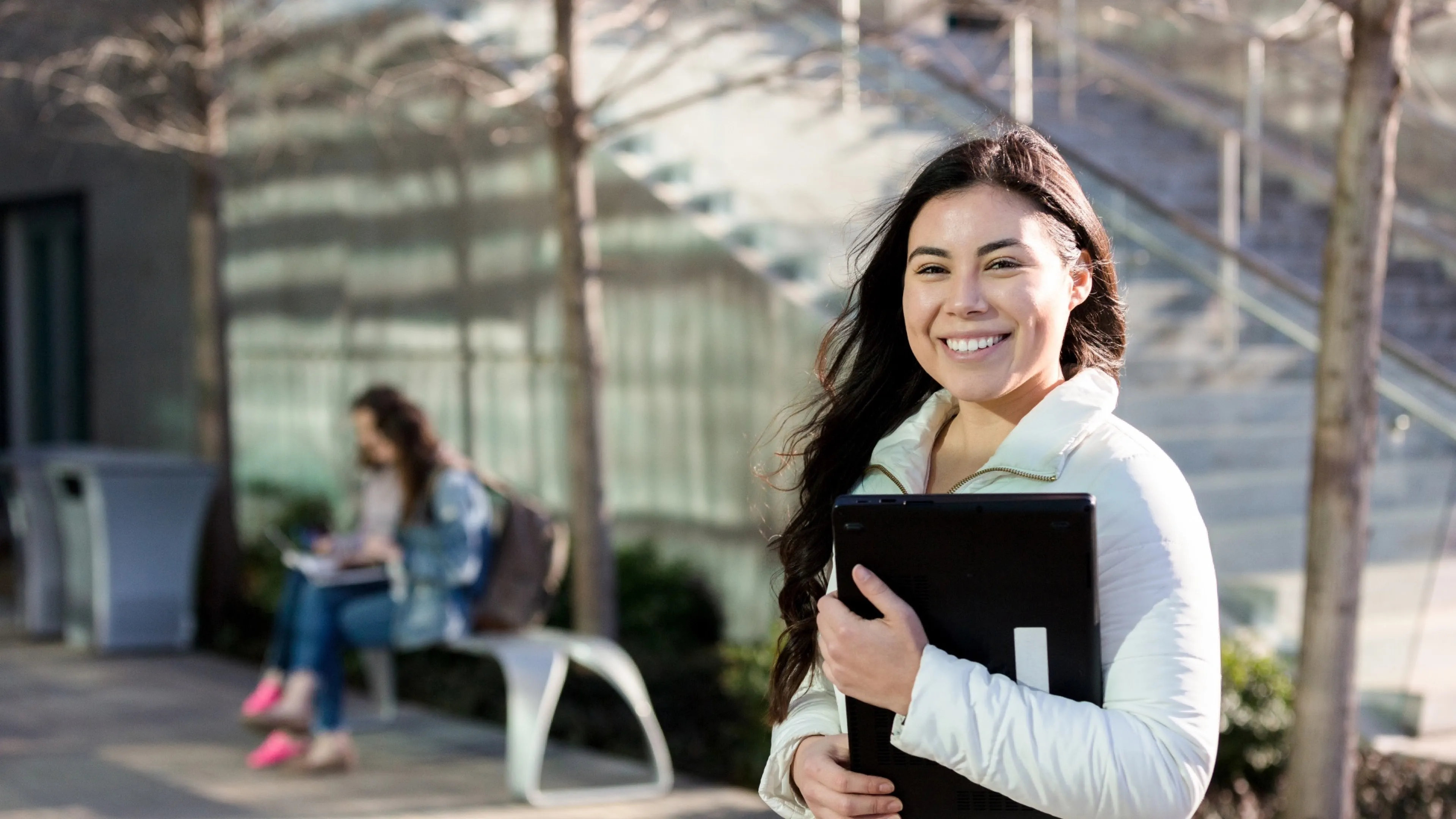 smiling young adult female student carries school supplies