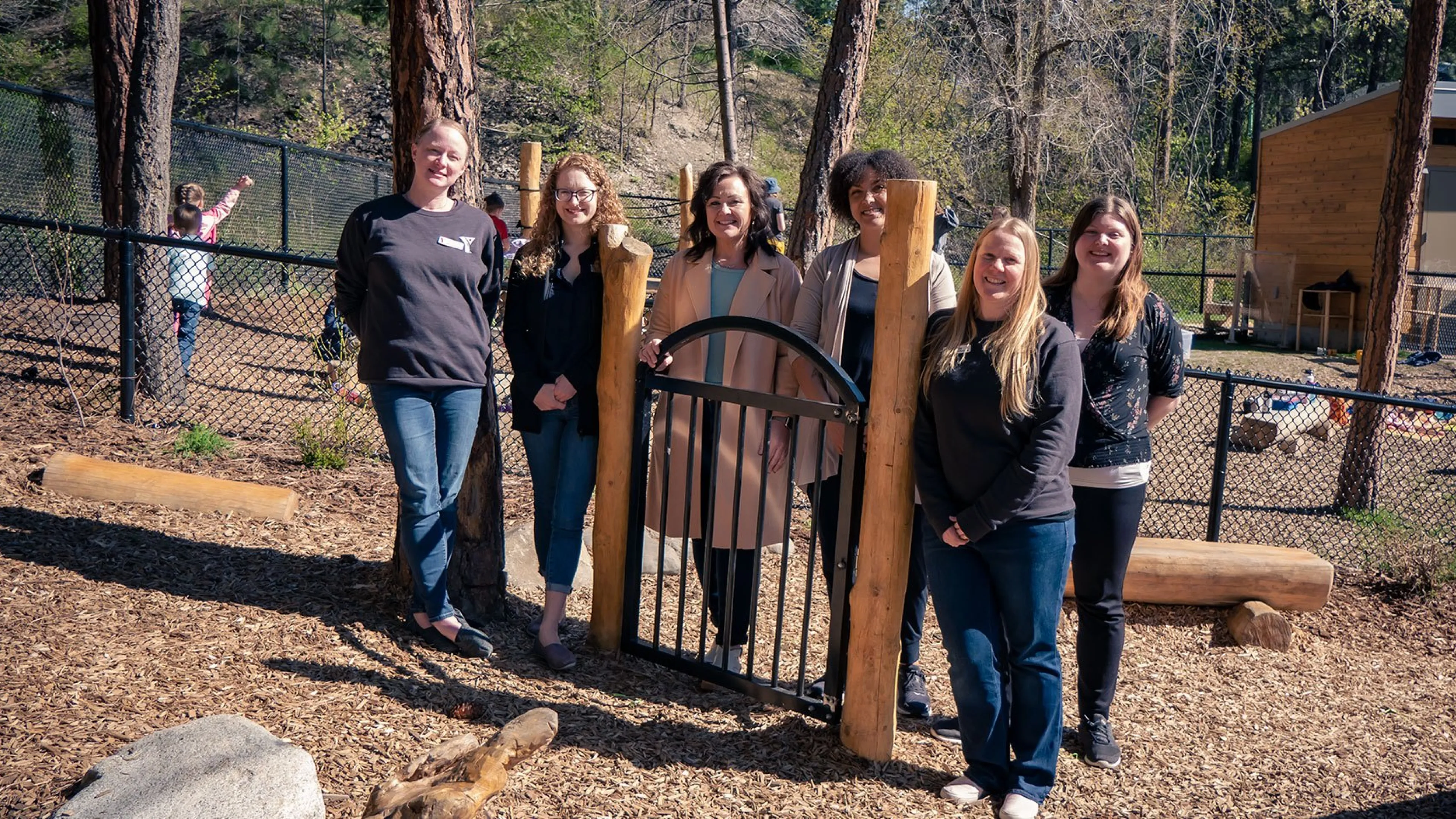 child care team standing in natural playground at Dilworth Mountain YMCA Child Care centre
