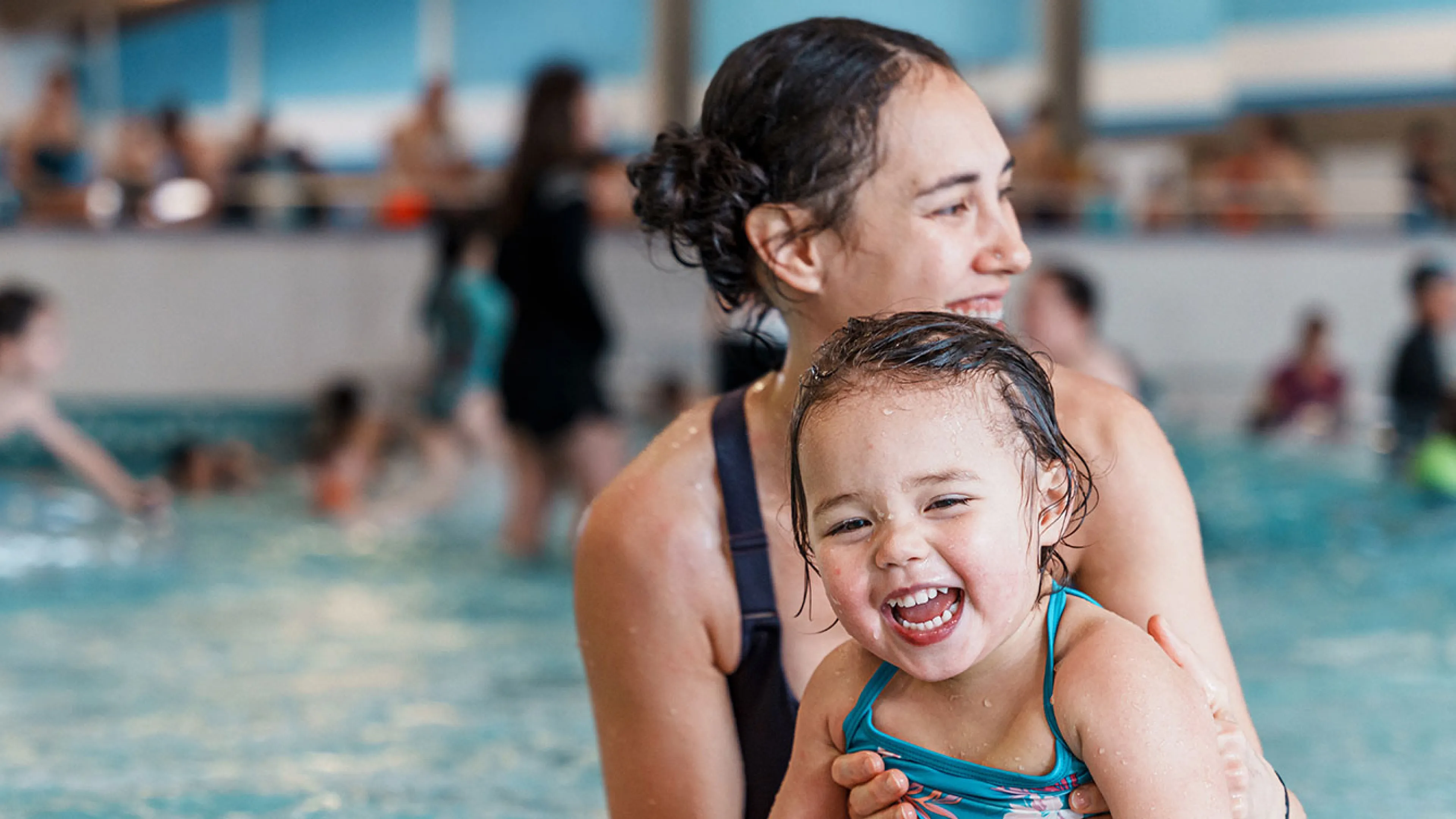 mother and young child having fun in a shallow pool area