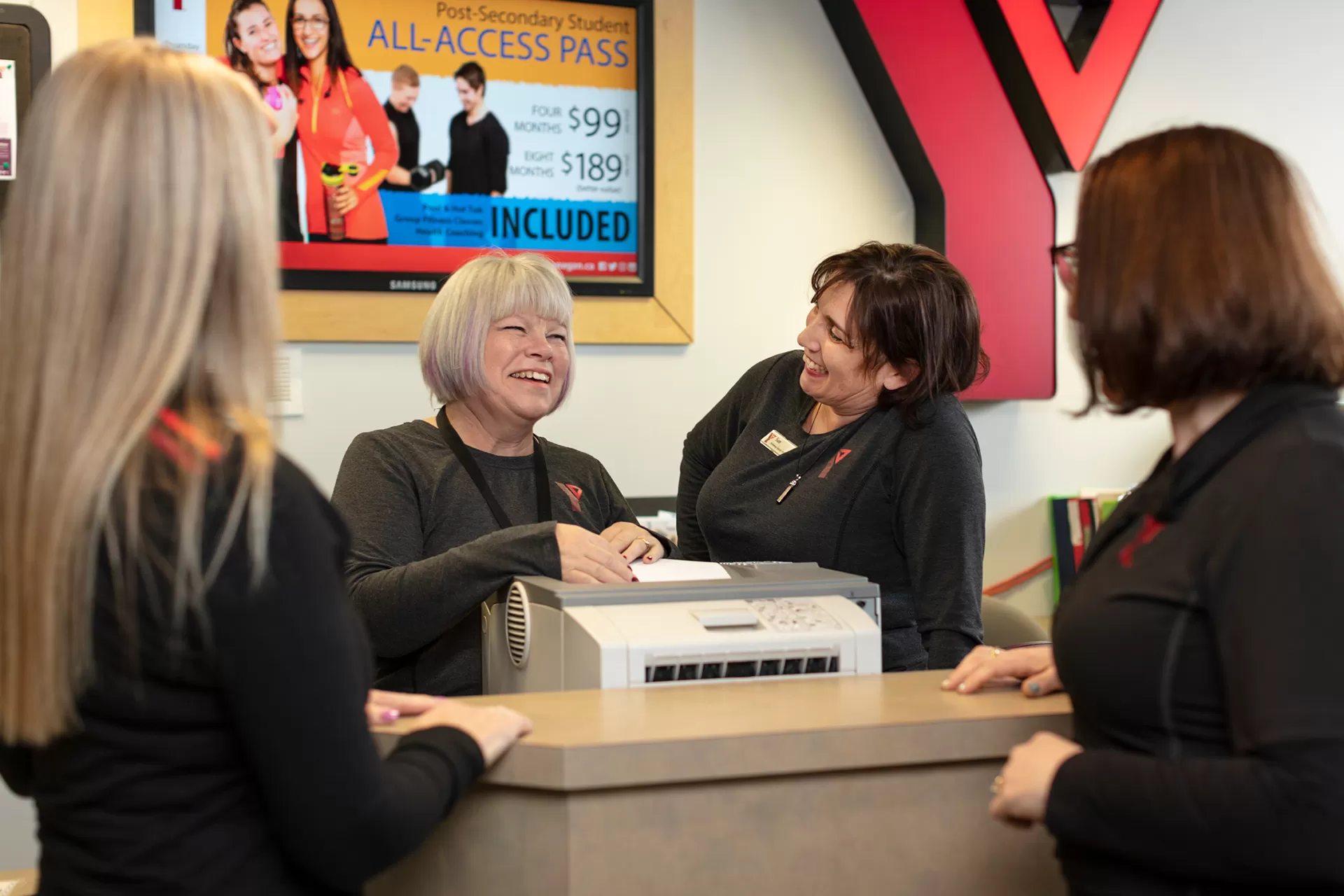 Women Smiling around the front desk