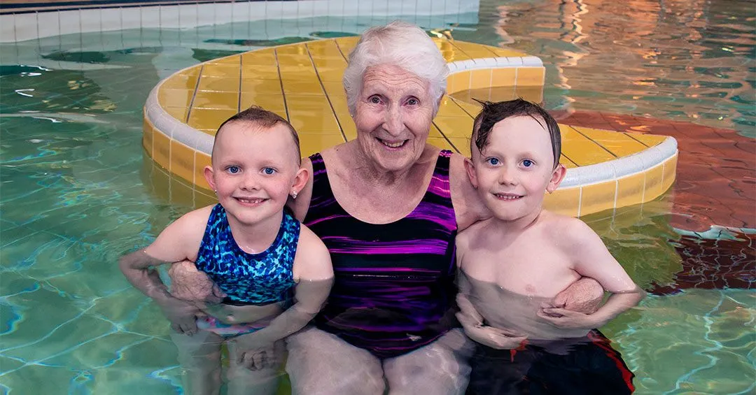 Jill smiles with happy children in leisure pool