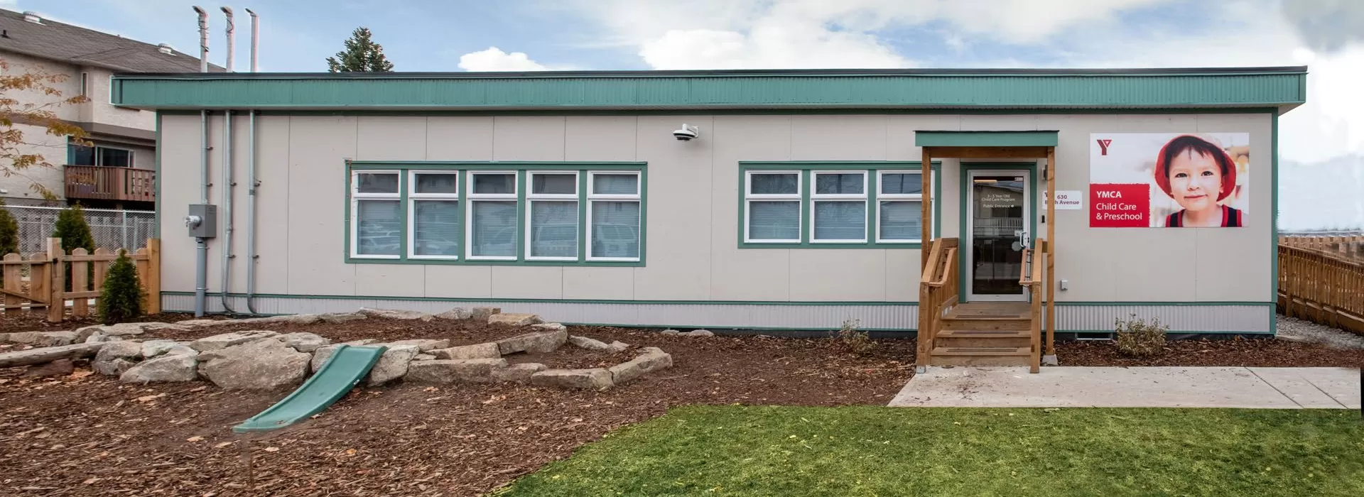 Queens Park YMCA Child Care exterior with small garden slide