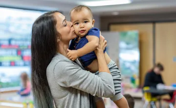 Brandi holding and kissing a baby