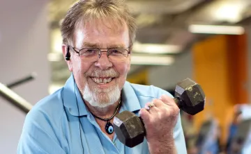 Bob smiling while lifting a dumbbell