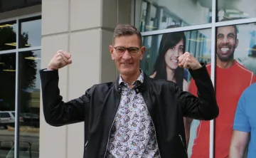 man in leather jacket flexing arms