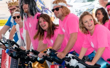 people in pink shirts riding bikes