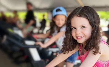 smiling girl riding stationary bike at the event
