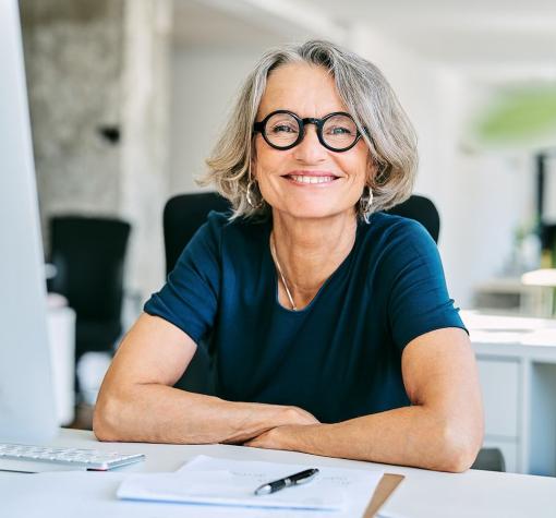 woman smiling while sitting in front of computer