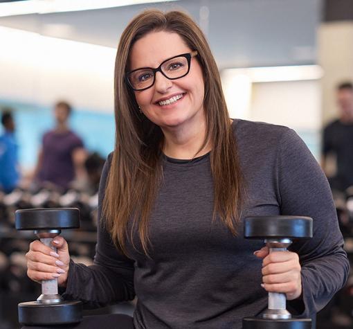 happy and confident woman holding weights